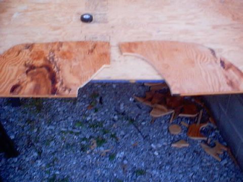 1999 Ford Taurus - Two custom-cut plywood pieces are shown, with debris scattered underneath.