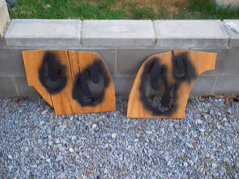 1999 Ford Taurus - Two wooden pieces with black spray paint are displayed outdoors.