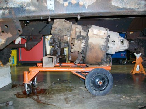 1979 Ford Bronco - Transmission and transfer case assembly being worked on, supported by a dolly.