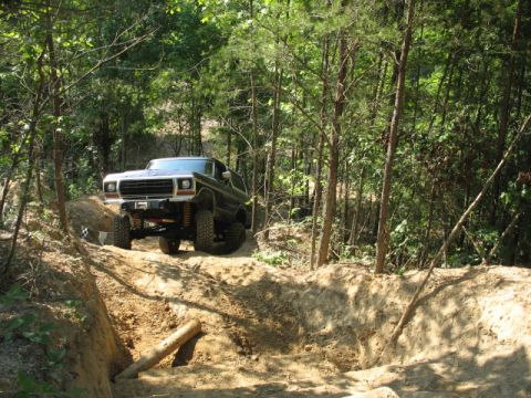 1978 Ford Bronco - 1978 Ford Bronco navigating a challenging off-road course through the woods.