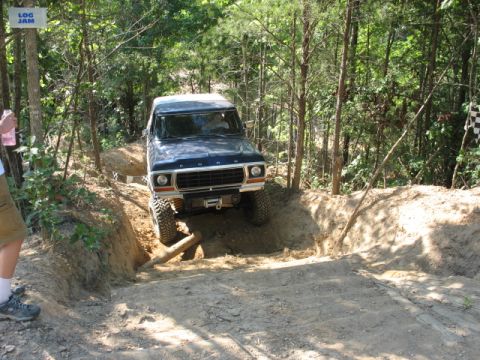 1978 Ford Bronco - A 1978 Ford Bronco navigates a challenging off-road course marked with a "LOG JAM" sign.