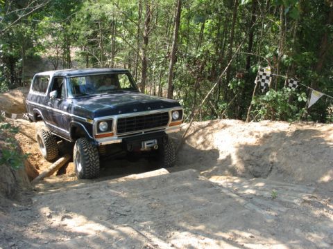 1978 Ford Bronco - This 1978 Ford Bronco navigates a challenging off-road obstacle course, complete with checkered flags marking the path.