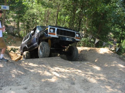 1978 Ford Bronco - This 1978 Ford Bronco is tackling an off-road course with a person watching nearby.