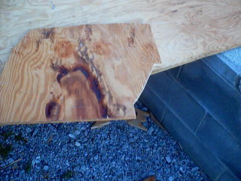 1999 Ford Taurus - A piece of plywood with dark stains is supported by cinder blocks and wooden braces.