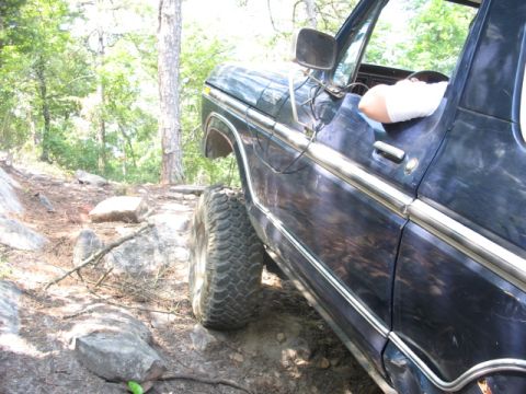 1978 Ford Bronco - 1978 Ford Bronco navigating a rocky trail with large off-road tires.