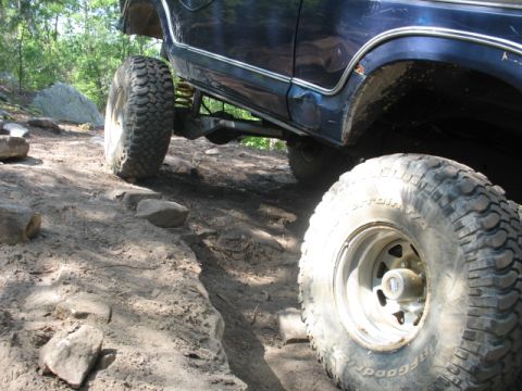 1978 Ford Bronco - 1978 Ford Bronco navigating a rocky, off-road trail with large tires.