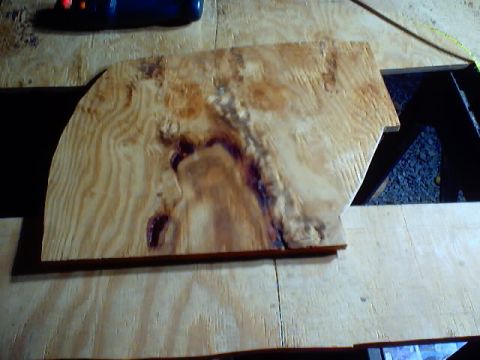 1999 Ford Taurus - A shaped piece of wood with interesting grain patterns and dark knotting is shown.
