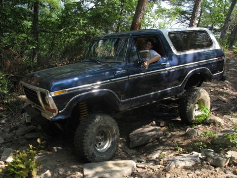 1978 Ford Bronco - A blue 1978 Ford Bronco navigates a challenging rocky trail with a driver inside.