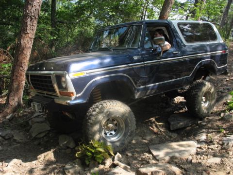 1978 Ford Bronco - This blue 1978 Ford Bronco navigates a challenging off-road course with large tires and a lifted suspension.