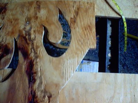 1999 Ford Taurus - Wooden carving detail with a measuring tape visible, against a dark background.