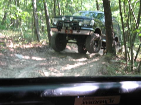 1978 Ford Bronco - 1978 Ford Bronco navigating an off-road trail in a forest.