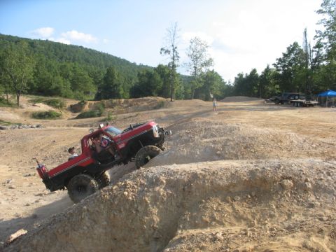 1978 Ford Bronco - A red 1978 Ford Bronco navigates a steep dirt incline during an off-road excursion.
