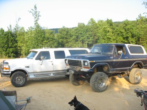 1978 Ford Bronco - Two Ford SUVs, a lifted Bronco and an Expedition, are parked side-by-side outdoors.