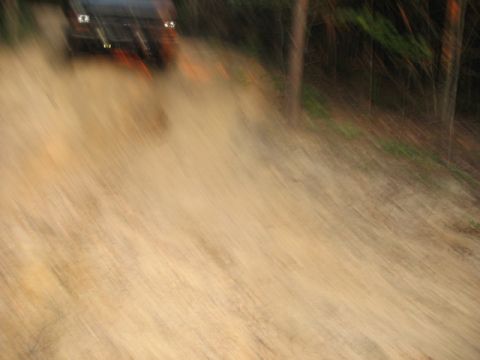 1978 Ford Bronco - Vehicle driving off-road on a dirt path, kicking up dust.