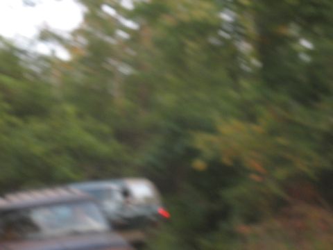 1978 Ford Bronco - Two vehicles are visible in this blurry scene, with one showing a red taillight.