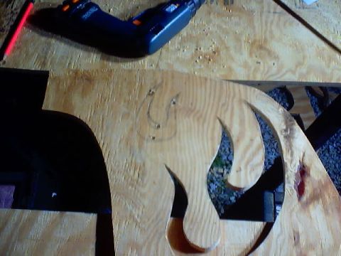 1999 Ford Taurus - Workbench scene with a wooden cutout, pencil, and a drill. Supermotors.net logo is present.