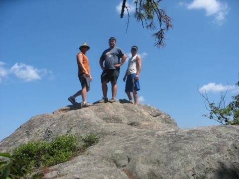 1978 Ford Bronco - Three men pose for a photo while standing atop a large rock formation on a sunny day.