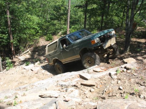 1978 Ford Bronco - Modified Ford Bronco tackling a challenging off-road course with steep inclines and large rocks.