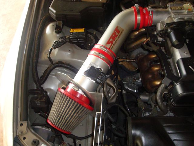 Polished SRI intake pipe with red couplers and cone filter in engine bay