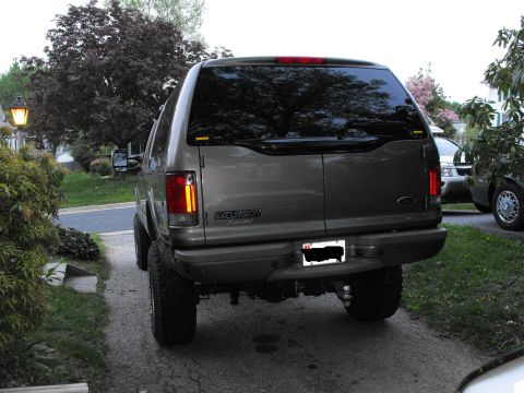 2003 Ford Excursion - Rear view of a lifted gray Ford Excursion parked in a driveway.