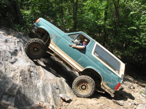 1978 Ford Bronco - This SUV is navigating a challenging rocky trail, its off-road capabilities.