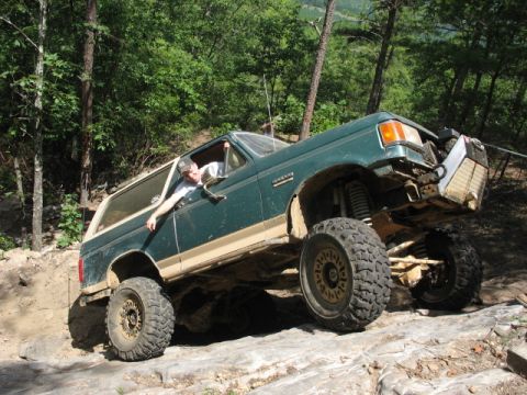 1978 Ford Bronco - A modified green Ford Bronco navigates a challenging off-road course.