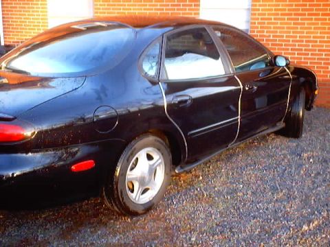 1999 Ford Taurus - This black 1999 Ford Taurus sedan is shown from the rear quarter angle.