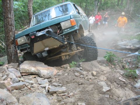 1978 Ford Bronco - An off-road vehicle navigates a challenging rocky trail with spectators observing the action.