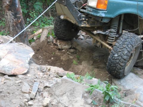 1978 Ford Bronco - A green off-road vehicle tackles a challenging rocky terrain, demonstrating its off-road capabilities.