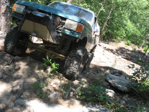 1978 Ford Bronco - This modified truck navigates a challenging off-road trail with steep inclines and rocky terrain.