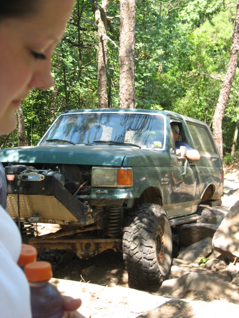 1978 Ford Bronco - This modified SUV is shown off-roading on a rocky trail, with its front grille removed.