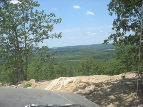 1978 Ford Bronco - View from inside a vehicle overlooking a vast expanse of trees and hills on a sunny day.