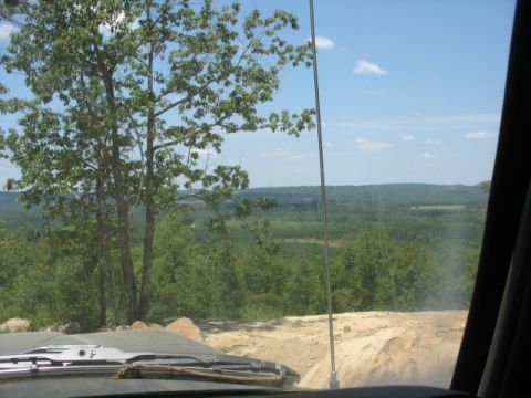 1978 Ford Bronco - View from inside a vehicle overlooking a vast expanse of green trees under a blue sky with scattered clouds.