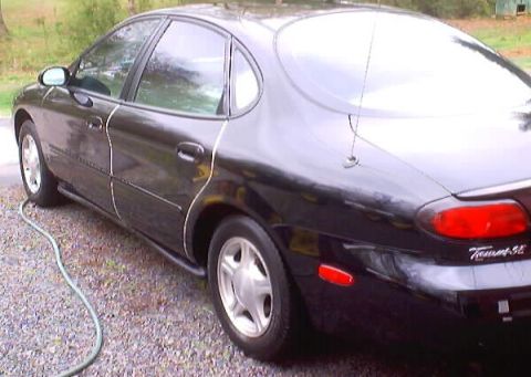 1999 Ford Taurus - This black 1999 Ford Taurus SE is shown from the rear quarter angle.