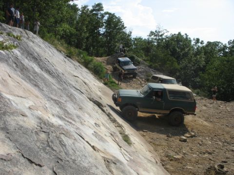 1978 Ford Bronco - Off-road vehicles navigate a challenging rocky terrain on a sunny day.