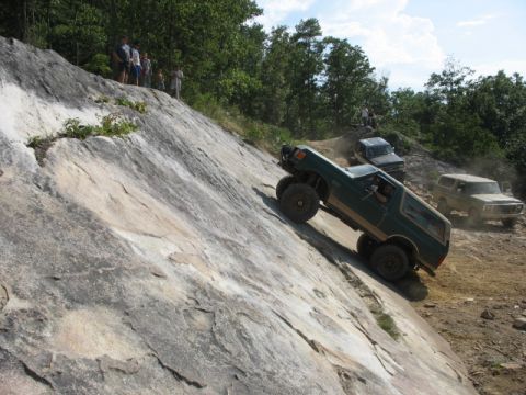 1978 Ford Bronco - Multiple off-road vehicles navigate a challenging rocky terrain on a sunny day.