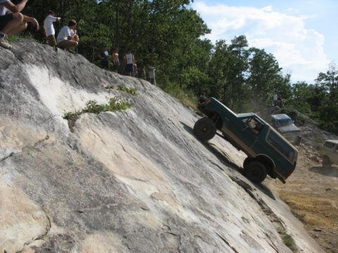 1978 Ford Bronco - 1978 Ford Bronco tackling a challenging rock climb with onlookers observing the action.