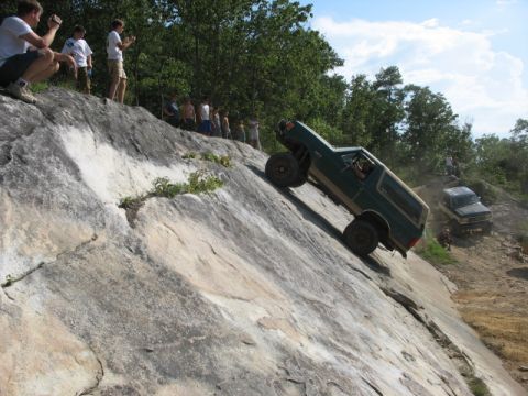 1978 Ford Bronco - A 1978 Ford Bronco navigates a challenging rocky incline, with spectators watching from above.