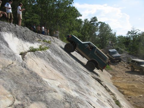 1978 Ford Bronco - A green 1978 Ford Bronco navigates a challenging rocky incline, with other vehicles and onlookers present.