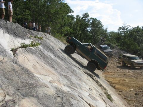 1978 Ford Bronco - 1978 Ford Bronco tackling a challenging off-road obstacle with onlookers present.