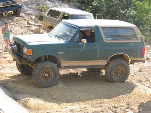 1978 Ford Bronco - Green Ford Bronco navigates a dirt trail with another Bronco in the background.