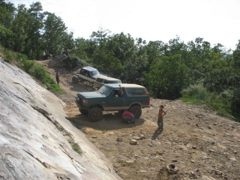 1978 Ford Bronco - Off-road vehicles navigate a rocky incline, with one SUV being serviced on the trail.