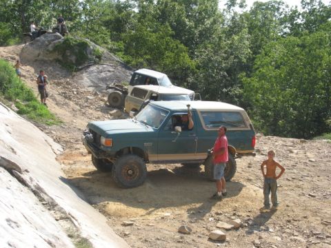 1978 Ford Bronco - Off-roading event with multiple vehicles navigating a challenging dirt path.
