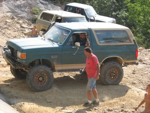 1978 Ford Bronco - Several off-road vehicles are seen on a dirt path, with one Bronco in the foreground.