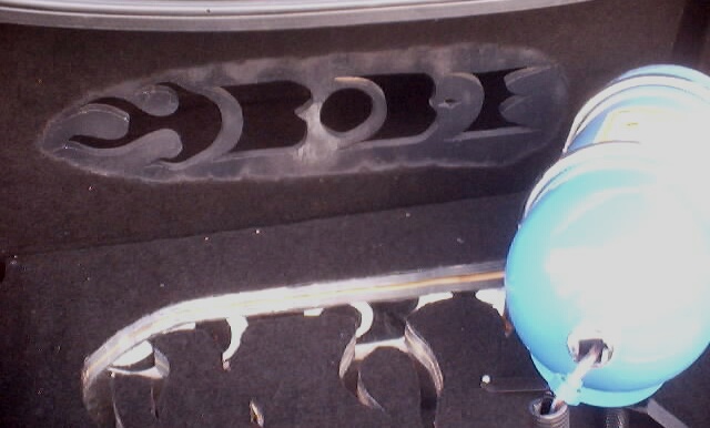 Trunk lining with cutouts and a blue canister. Text 'SUPERMOTORS' visible