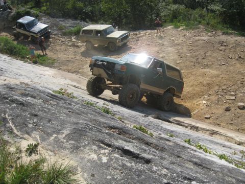 1978 Ford Bronco - Multiple off-road vehicles navigate a challenging rocky terrain during an event.