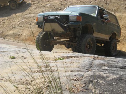 1978 Ford Bronco - This modified SUV is navigating a rocky terrain, its off-road capabilities.