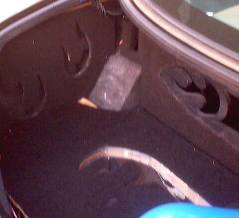 1999 Ford Taurus - The interior of a car's trunk is shown, with visible carpet and structural elements.