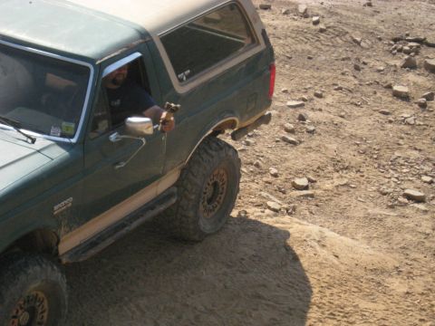 1978 Ford Bronco - A Ford Bronco navigates a rocky, off-road trail with a driver behind the wheel.