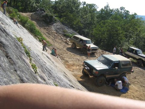 1978 Ford Bronco - People and off-road vehicles gather on a steep, rocky terrain during an outdoor excursion.